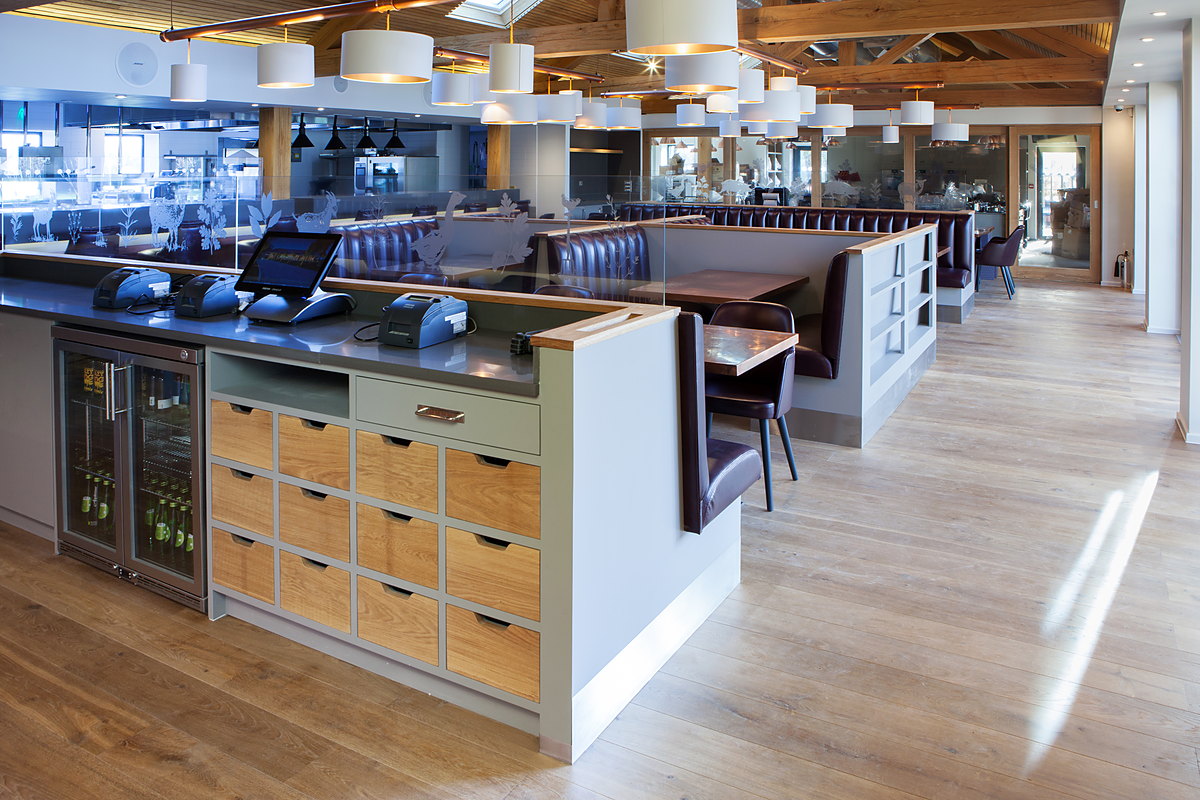 Bar and servery with oak drawer banks and banquette booths