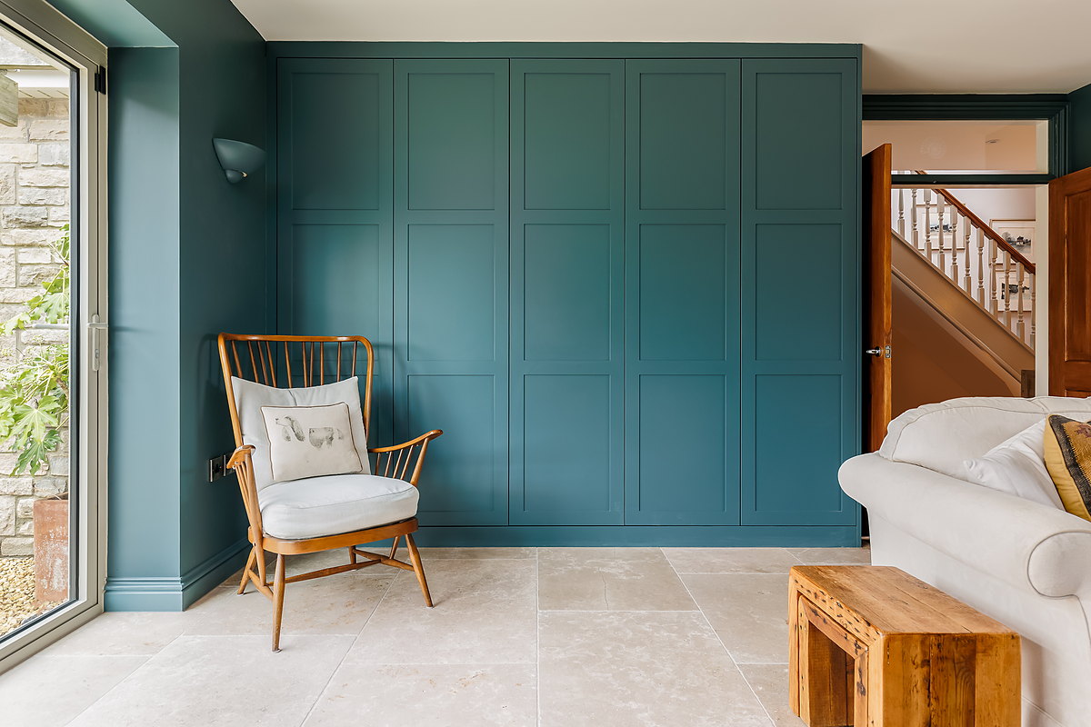 A deep-green panelled lounge wall with fitted joinery